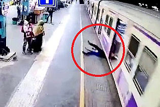 印度男子抓住一列行驶中的火车车门试图跳上车