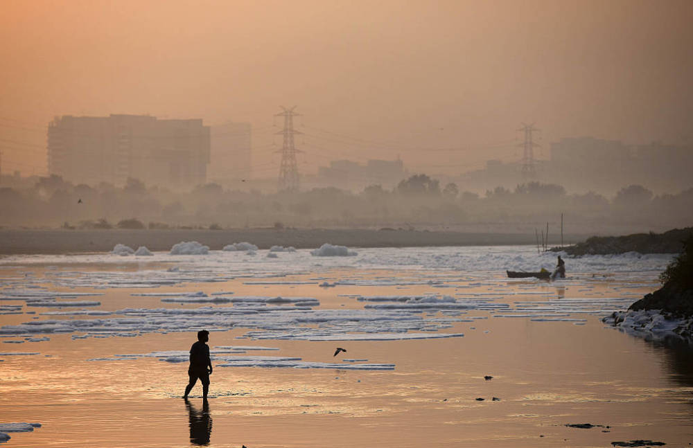 印度亚穆纳河因污染出现白色有毒泡沫当地渔民在云海中前行