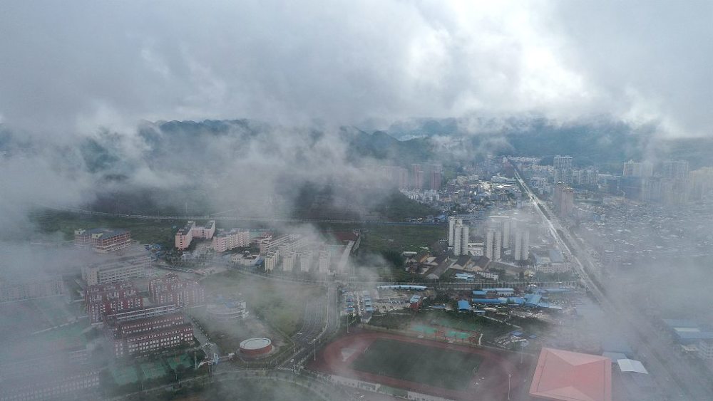 2020年8月3日,贵州黔西南,航拍安龙县县城云雾缭绕,楼房与远山在雾中