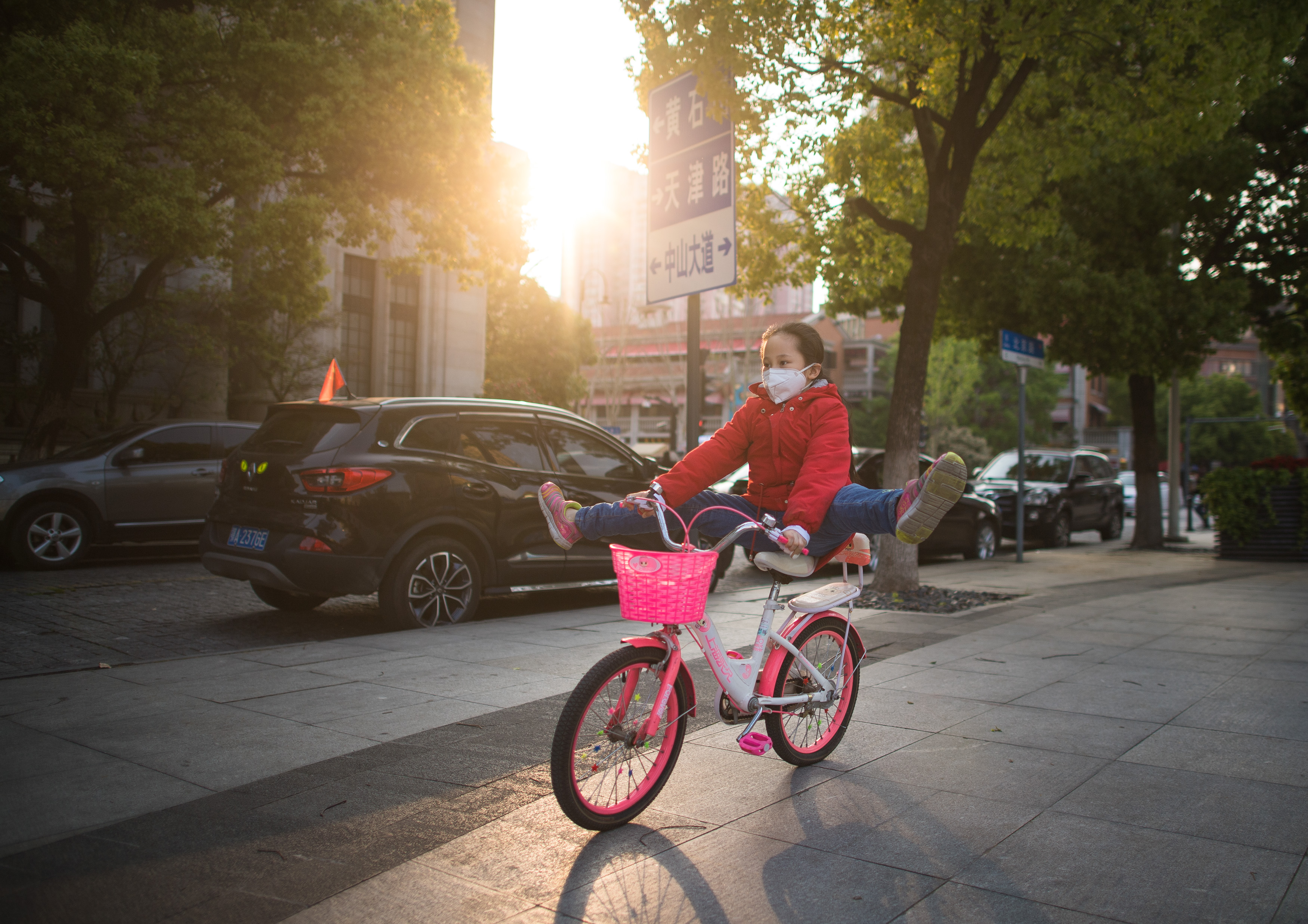 4月12日,小朋友在吉庆街附近骑单车.