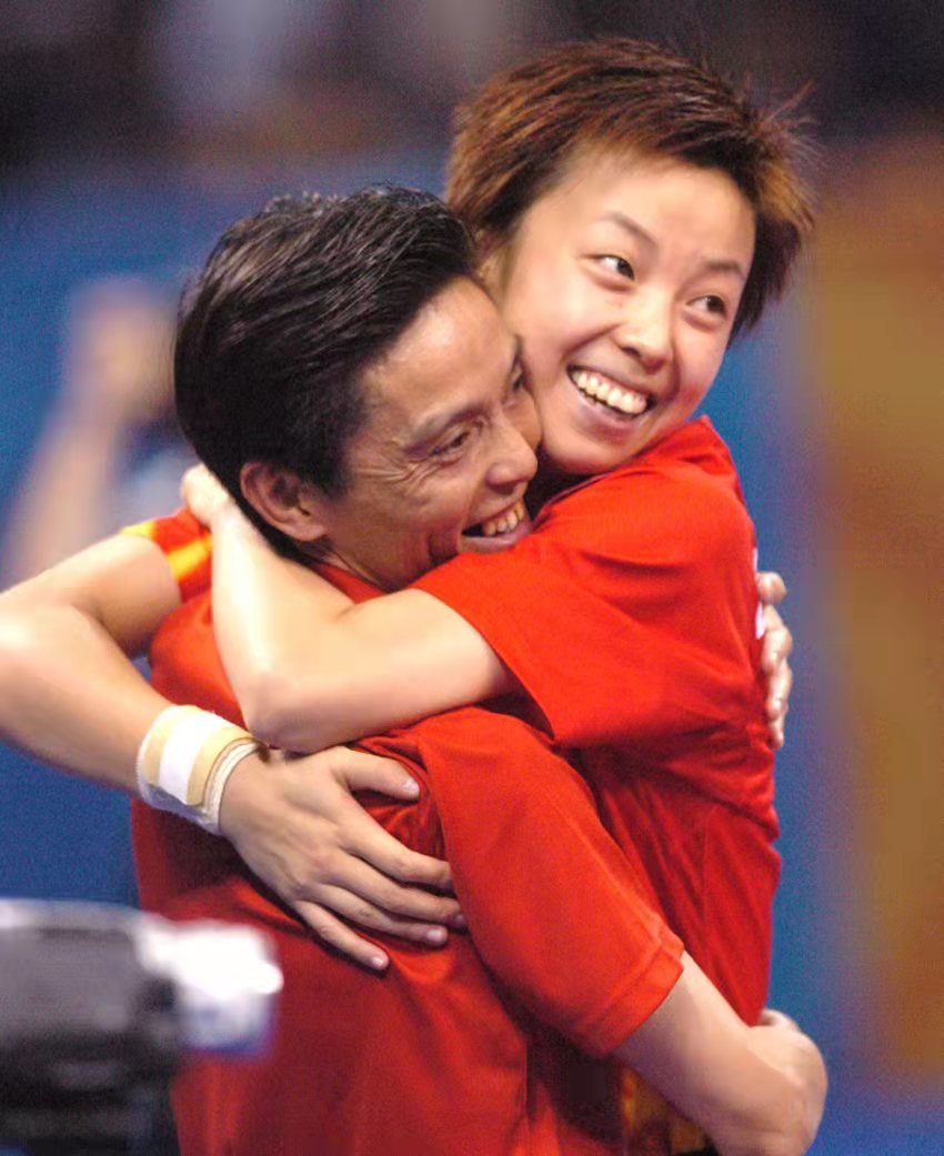 2004年雅典奥运会，张怡宁夺得乒乓球女单冠军后，与教练陆元盛热烈拥抱。王霞光/摄 受访者供图