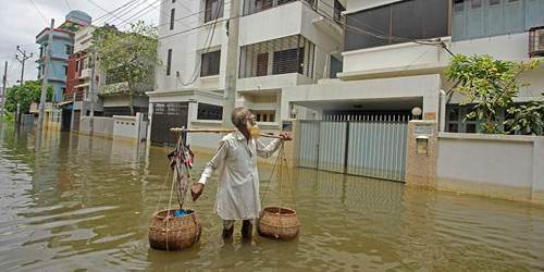 孟加拉国发洪水致社区被淹 商贩蹚水沿街叫卖