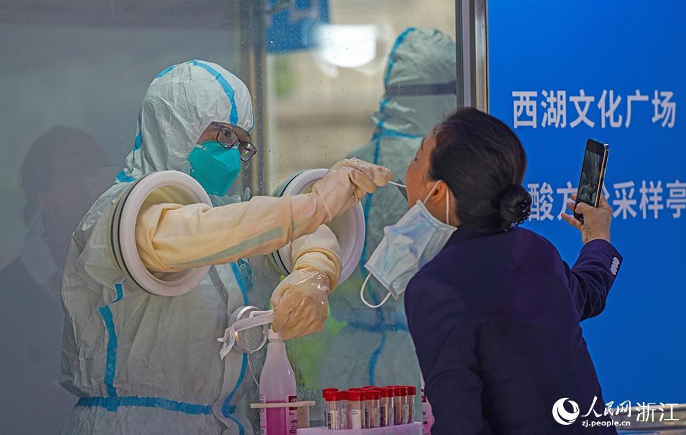 医护人员在正压核酸采样亭里为市民进行无接触式核酸检测。人民网 章勇涛摄